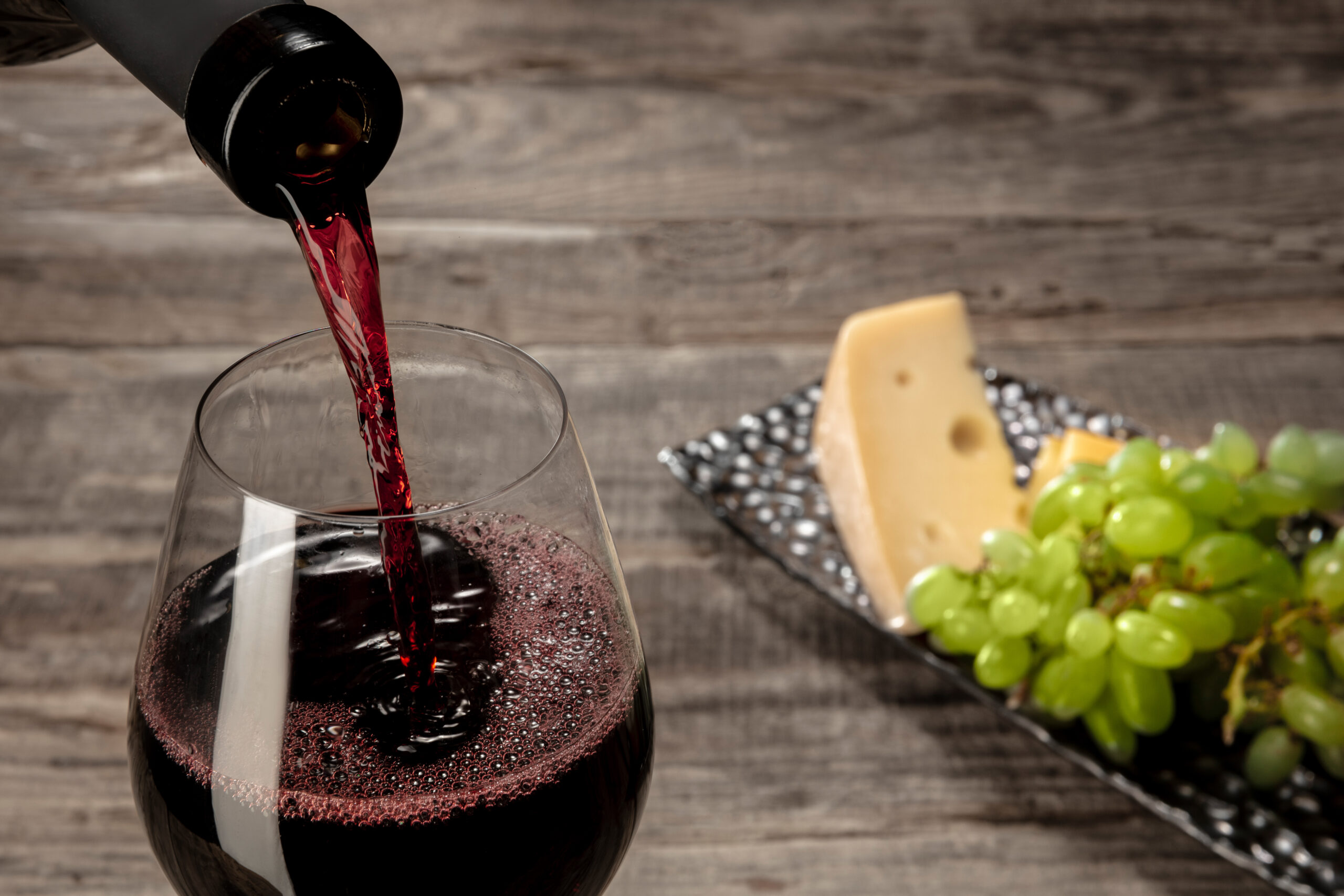 A person pouring wine into a glass