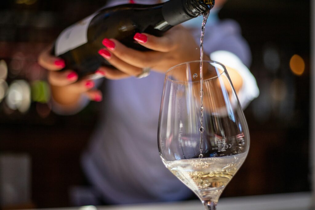 A person pouring a bottle of wine in a glass