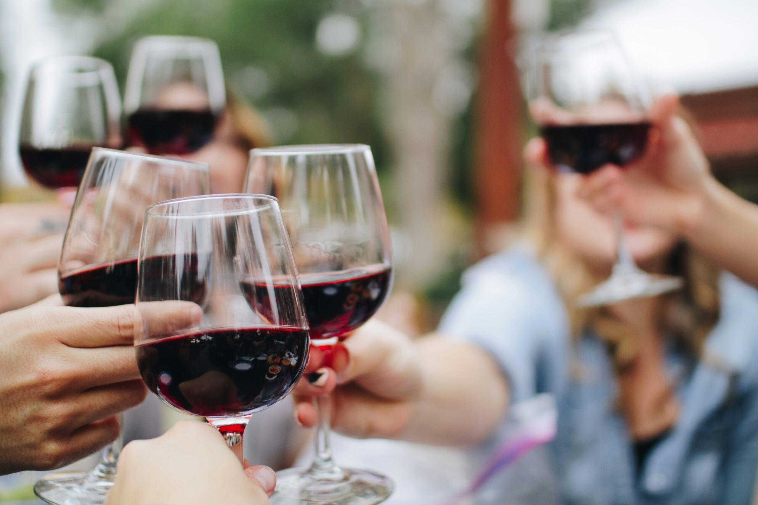 People holding a glass of red wine