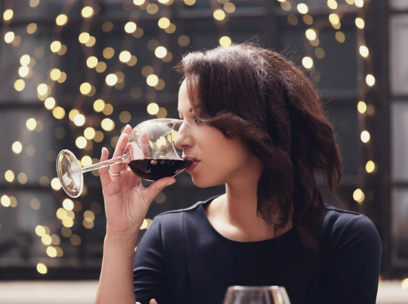 A woman in the restaurant having a sip of her wine