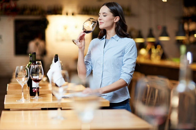A woman tasting wine for their restaurant business