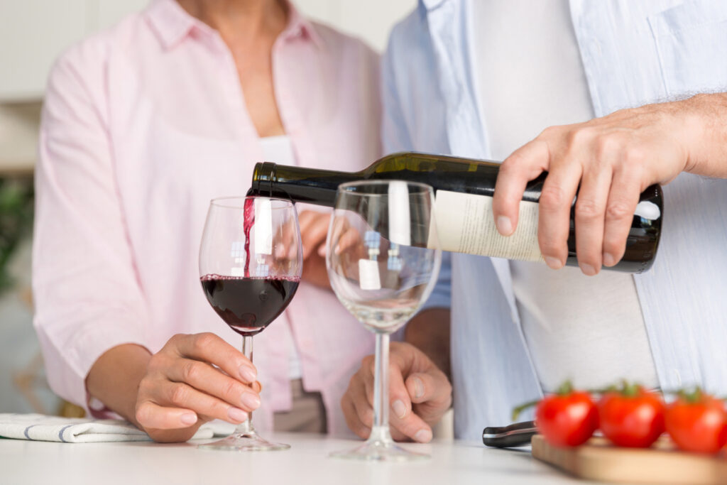 Pouring red and white wine into the glass