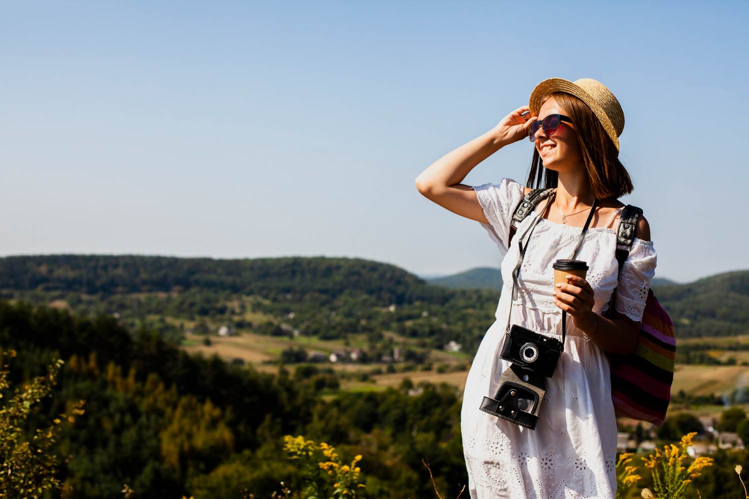 A lady in a dress with a camera