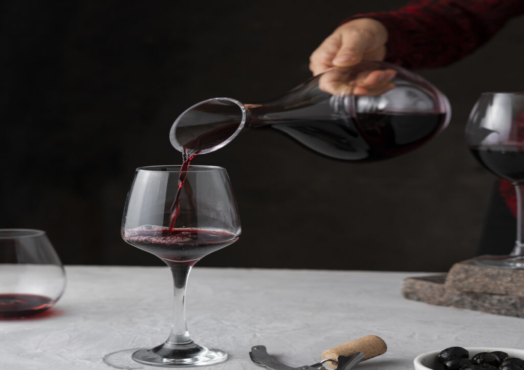 A man pouring a decanted red wine